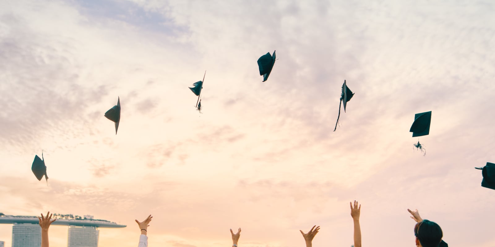 Graduates throwing hats into the air